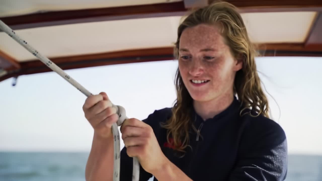 Young Sailor Ties Knots on a Boat During Afternoon Sail off the Coast