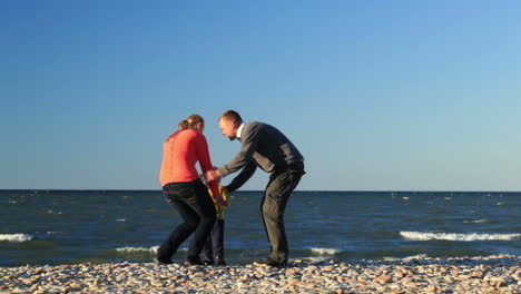 Family-of-three-on-pebble-beach