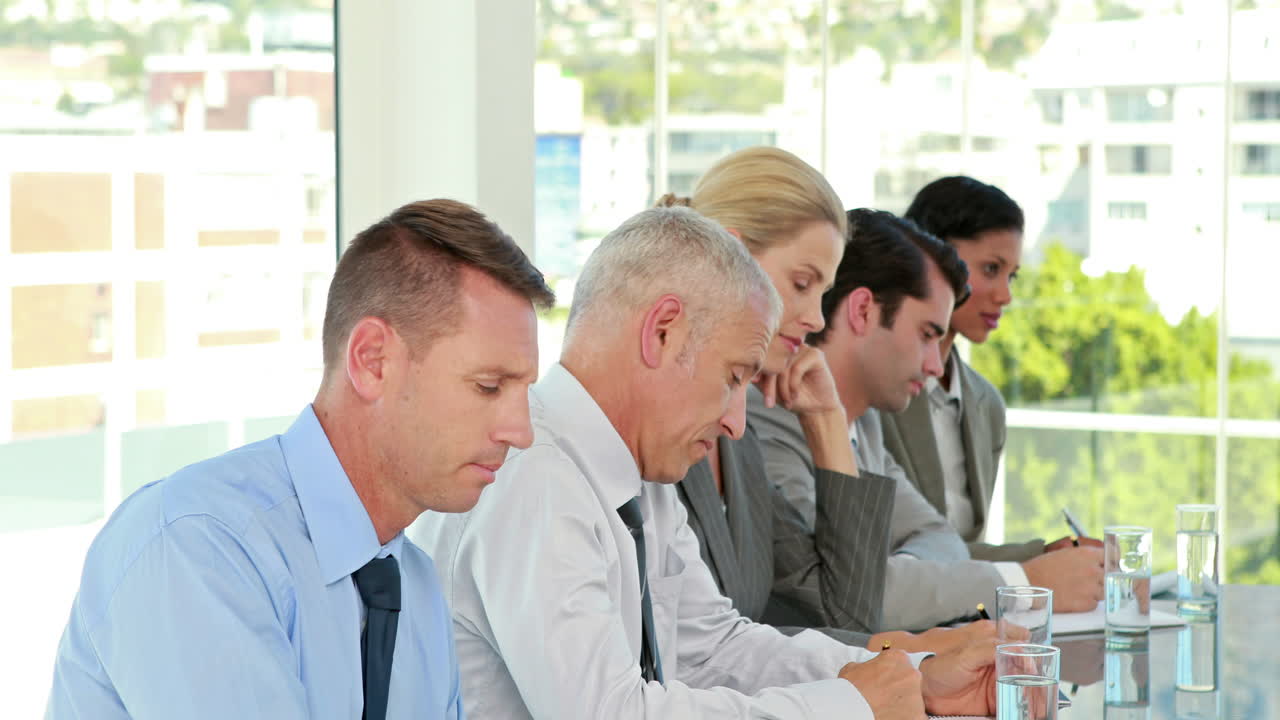 비즈니스 팀은 컨퍼런스 중에 메모를 취합니다.