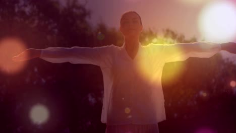 digitally generated video of glowing spots moving against woman performing yoga in background