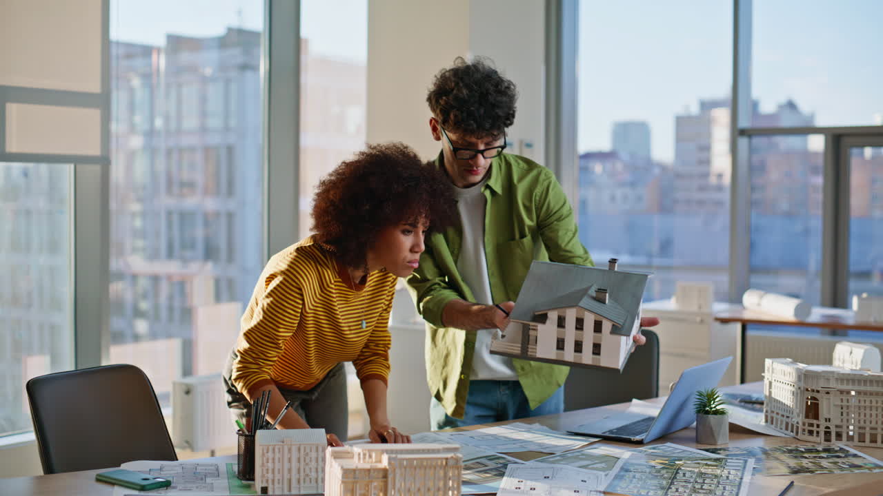 Two engineers planning house construction at company office. Designers working