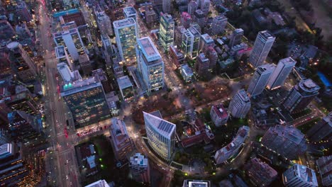 Drone-Sobre-La-Moderna-Ciudad-Latinoamericana-El-Golf-Barrio-Santiago-Chile-Noche-Vista-Aérea,-Ciudad-Escénica-De-Alta-Gama