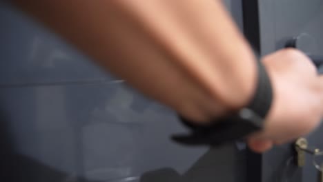 close-up of hand unlocking gray door with a key. perfect for security, privacy, or facility access scenarios.