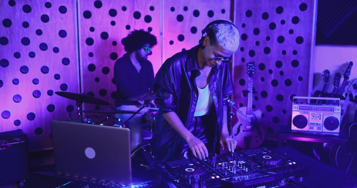 DJ donna che mixa musica con le cuffie in uno studio illuminato di viola