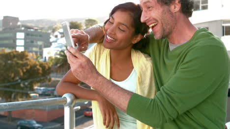 Happy-business-couple-looking-at-a-smartphone