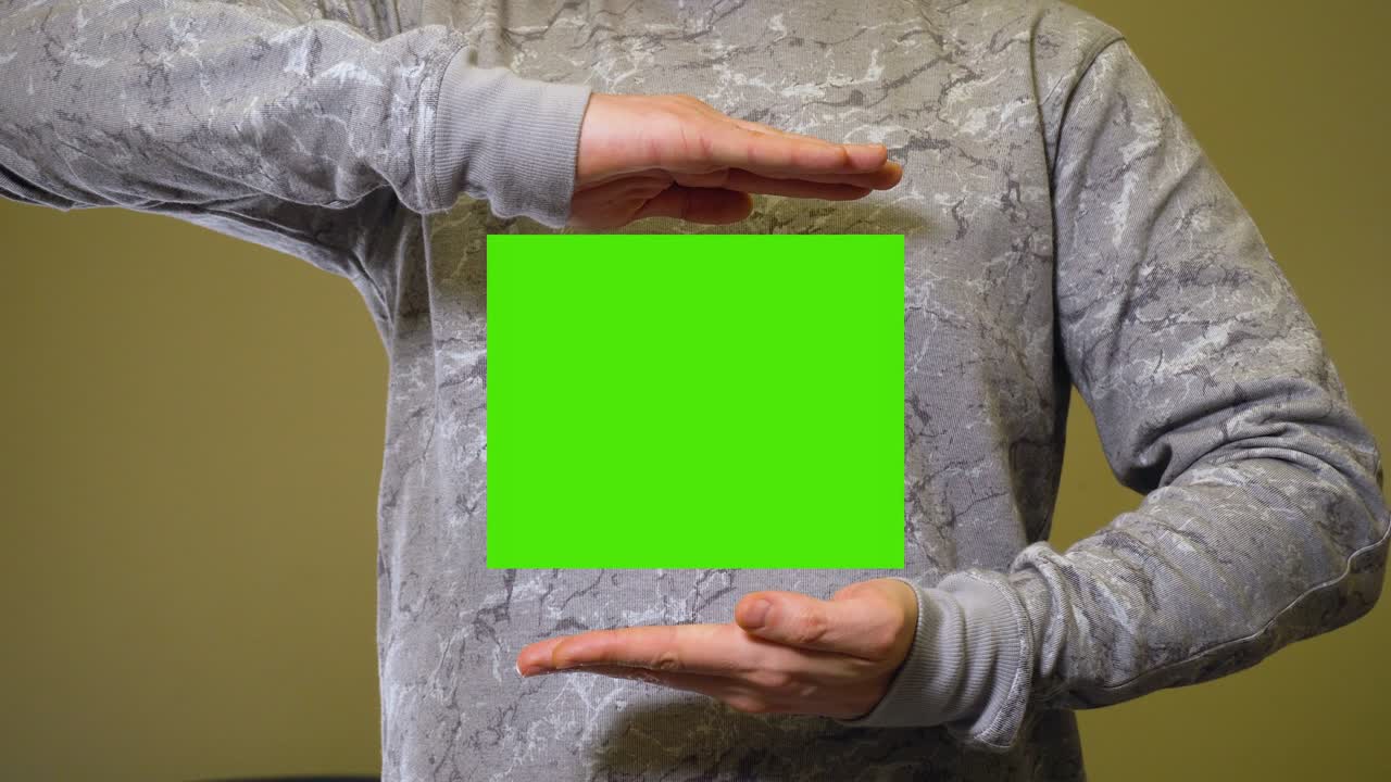 Mand spreder hænderne og åbner grøn skærm chromakey banner.