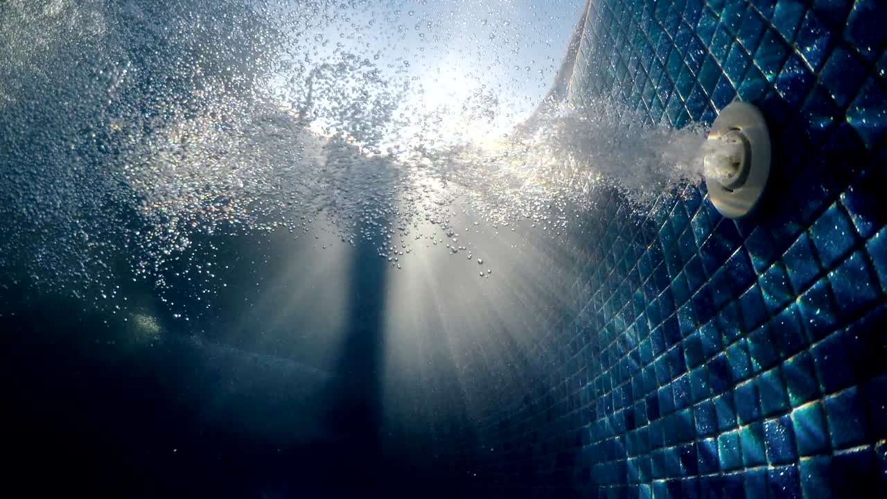 온수 스파 수영장에서 공기 거품과 물의 파동. 빛이 반이는 수중 풍경