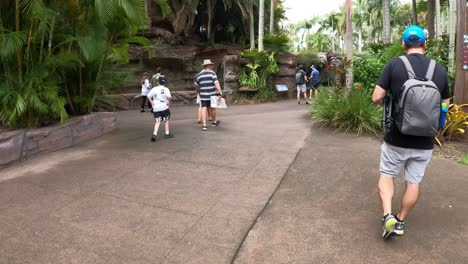 people walking through lush greenery in a park