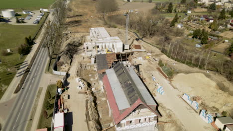 Restoration-of-a-historic-building-located-near-a-road-and-tall-trees,-aerial