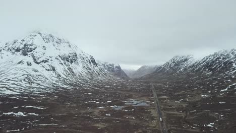 Sobrevuelo-Aéreo-De-Tierras-Altas-Con-Carreteras-Y-Automóviles-Durante-El-Día-Nevado-De-Invierno-En-El-Paisaje-De-Escocia