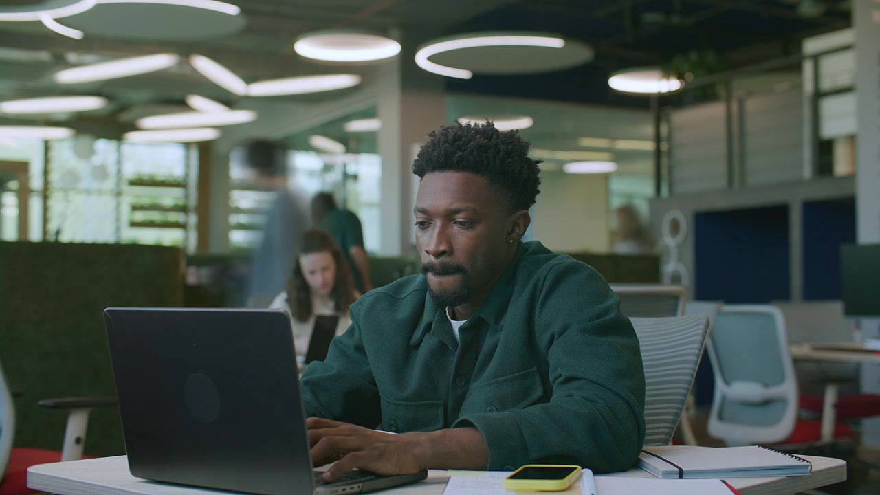 Timelapse of Black Employee Typing on Laptop and Taking Notes during Office Day