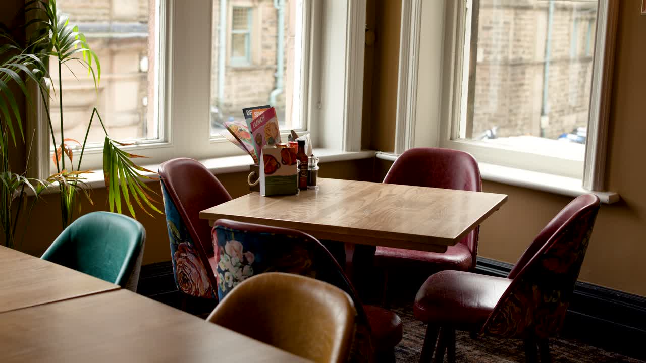 Empty retro cafe corner with leather chairs, natural daylight, static camera, cozy vintage atmosphere