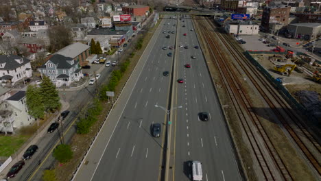 Busy-multilane-trunk-road-on-suburbs.-Tilt-up-reveal-of-cityscape-and-downtown-skyscrapers-in-distance.-Boston,-USA