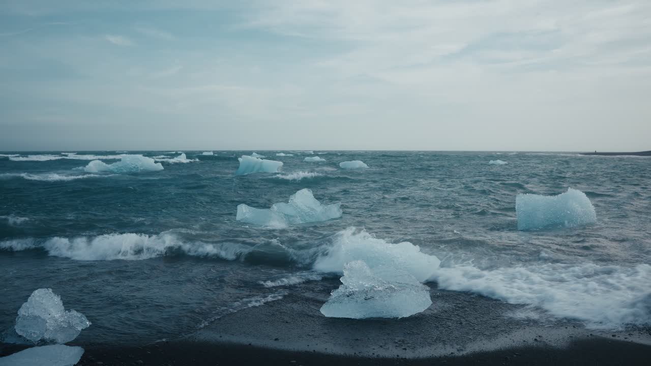 Diamond Beach, Iceland, ice pieces with waves crashing onto black sand, scenic