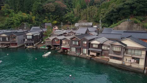 aerial drone panoramic of stilt traditional japanese houses near sea coastline in kyoto beach, kyotango seascape with birds and asian atmosphere by, wooden homes, travel destination