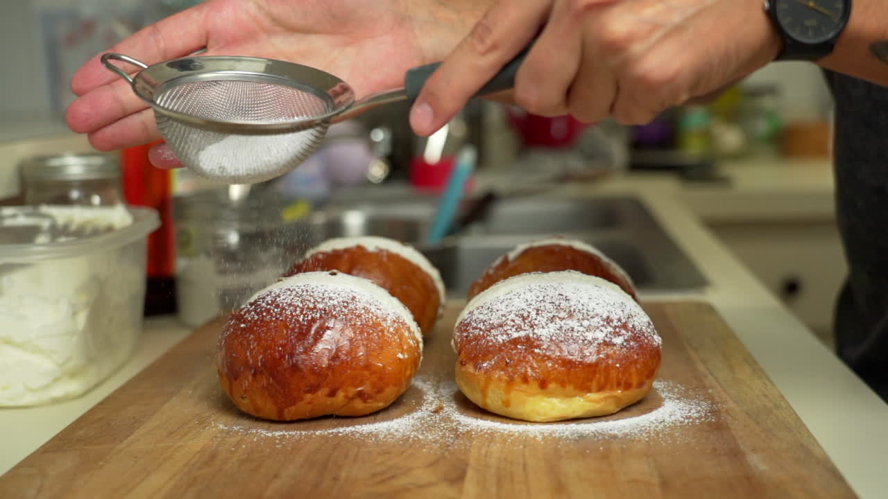el panadero está preparando un poco de pastelería espolvoreando azúcar en polvo encima de un delicioso pastel relleno de crema