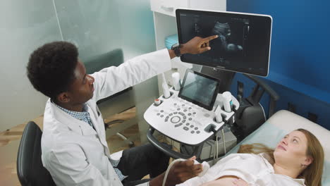 médico que realiza un ultrasonido en una mujer embarazada