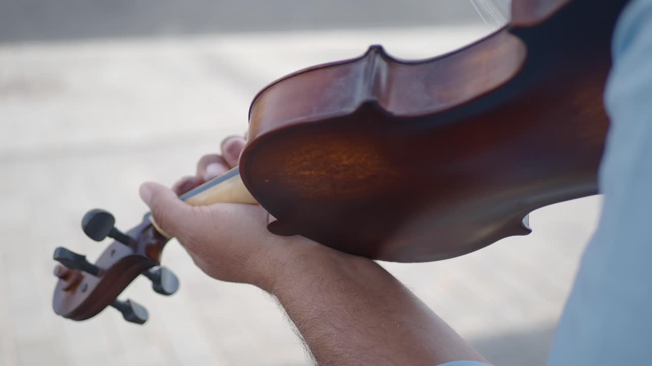 A man plays the violin in a city street.