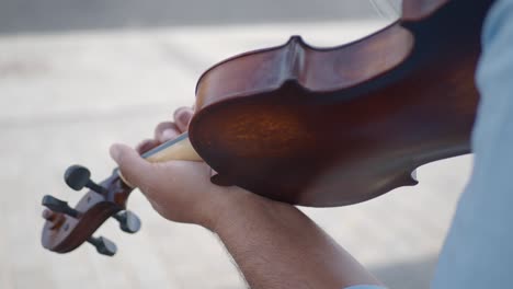 un hombre toca el violín en una calle de la ciudad.
