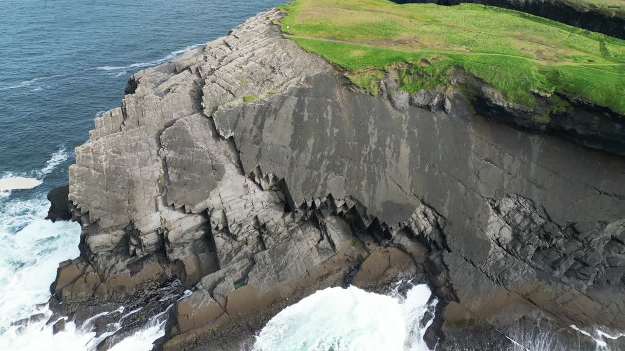 Kilkee Klipperne med bølger, der slår mod en barsk kystlinje, ingen mennesker, om dagen, luftfoto.