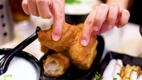 hands interacting with fried dough and soup