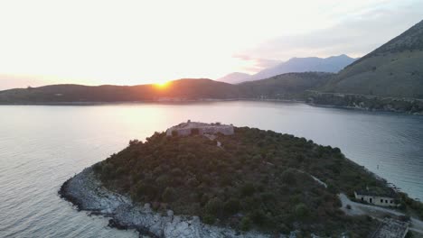 vista aérea del castillo de porto palermo en la riviera albanesa con la puesta de sol sobre las montañas