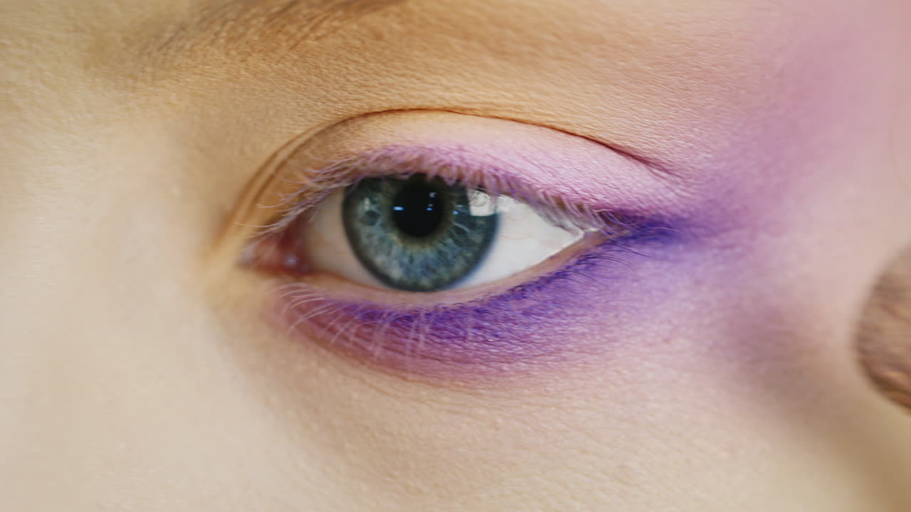 aplicar maquillaje en un hermoso ojo femenino de color azul