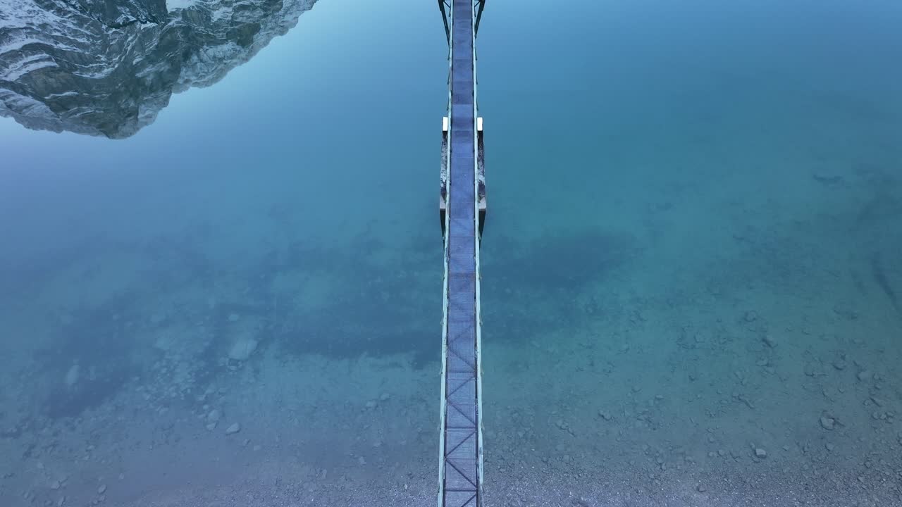 A clear turquoise lake, klöntalersee, glarus, switzerland, with a bridge, aerial view