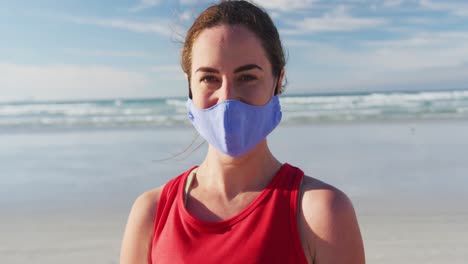 portrait of caucasian woman wearing face mask at the beach