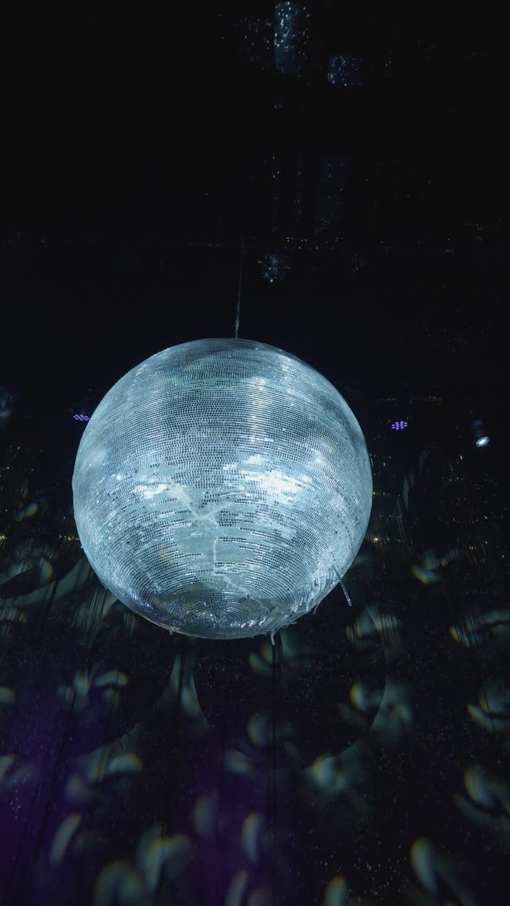 Verticale - Palla da discoteca a specchi sospesa in uno spazio interno buio