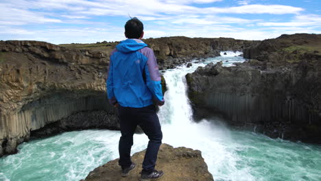 viajero haciendo senderismo en la cascada de aldeyjarfoss en islandia.