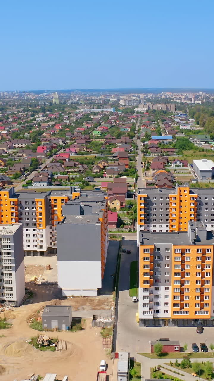 Panoramic view of a city. Multi-storey apartment buildings built in the new city district. Modern residential high-rise complex. Aerial view. Vertical video