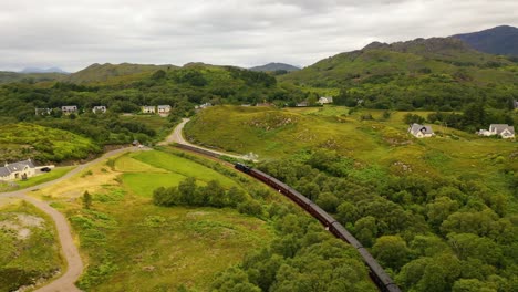 aerial shot of steam train moving through scottish highlands, scotland, united kingdom