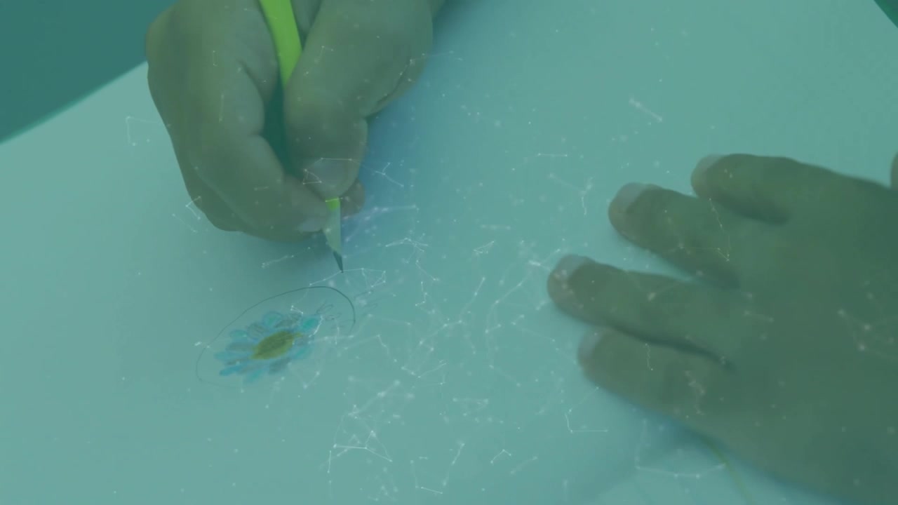 Child's Hand Drawing and Coloring a Flower on Paper