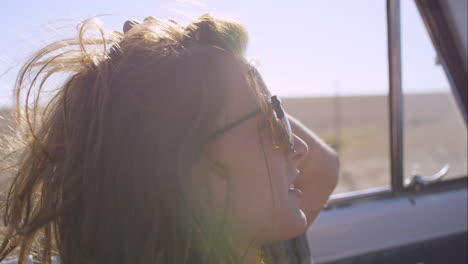 beautiful girl taking photos with smart phone on road trip in convertible vintage car