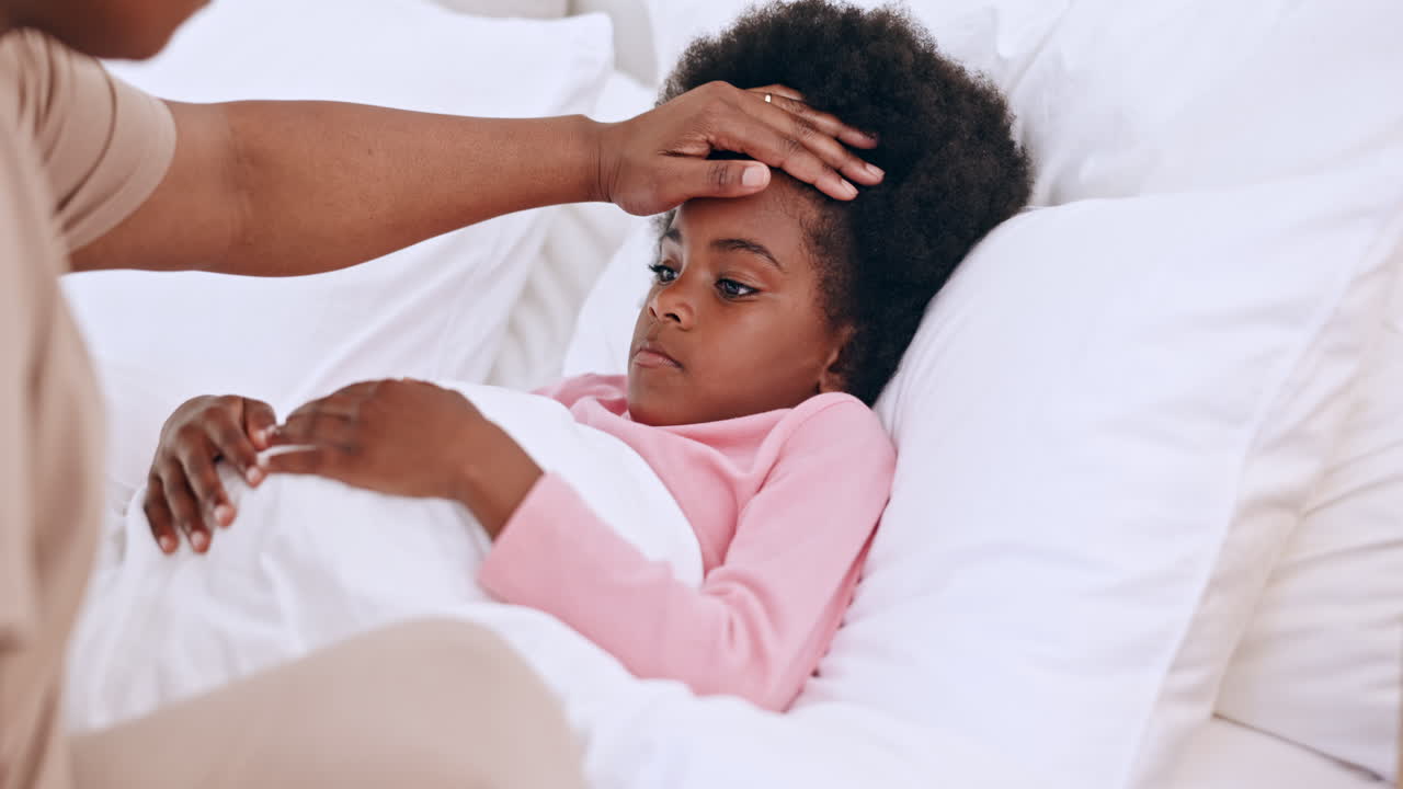 Madre, bambino e mani sulla fronte a letto
