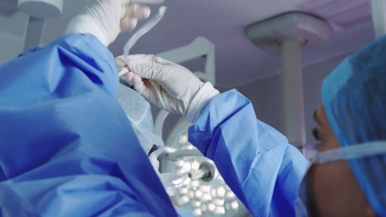 수술실에서 수술 마스크를 착용하는 남성 의사를 돕는 여성 의사의 클로즈업