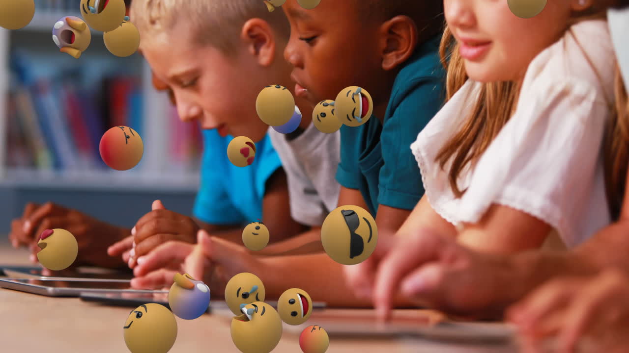 Emoji icons with school children using tablets in the background 4k