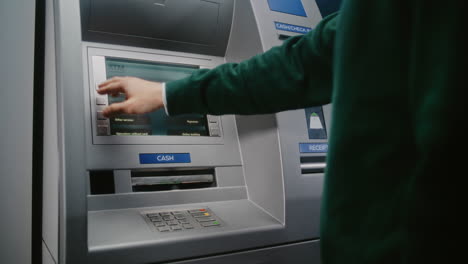 unrecognizable person entering pin code on atm keypad to withdraw money. error message on cash machine display about transaction cancellation due to incorrect pin code. banking equipment. close up.