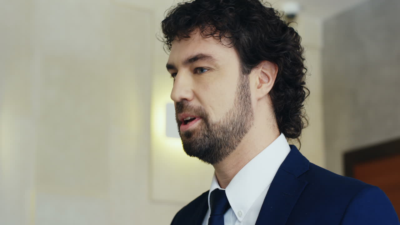 공식적인 옷을 입고 회의실에서 이야기하는 연단에 있는 백인 사업가 연사의 클로즈업 보기