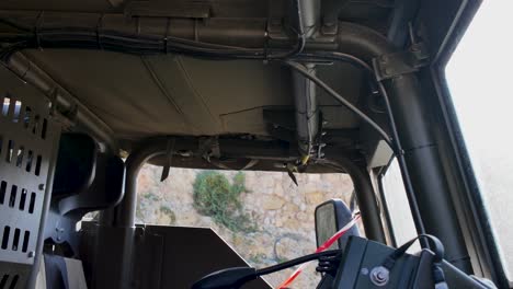 inside view of military vehicle cockpit showing equipment and reinforced panels
