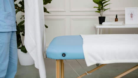 Physiotherapist-preparing-the-massage-bed