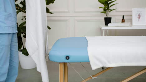 physiotherapist preparing the massage bed