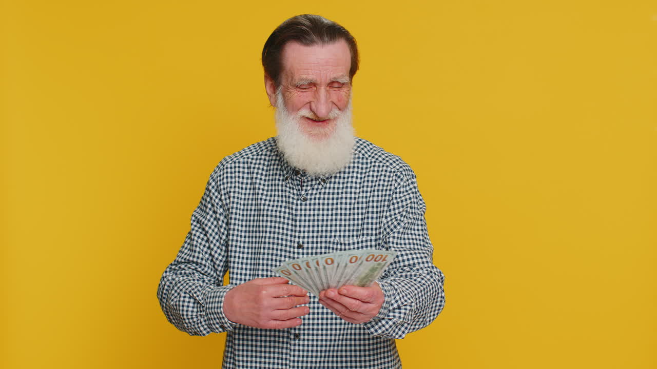 Rik, lykkelig eldre mann, vinner, vifter med pengesedler som en vifte, stor inntekt, rikdom, suksess, business