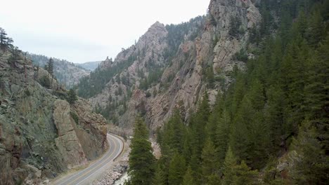 aerial ascent of road along river through steep rock cliffs, colorado