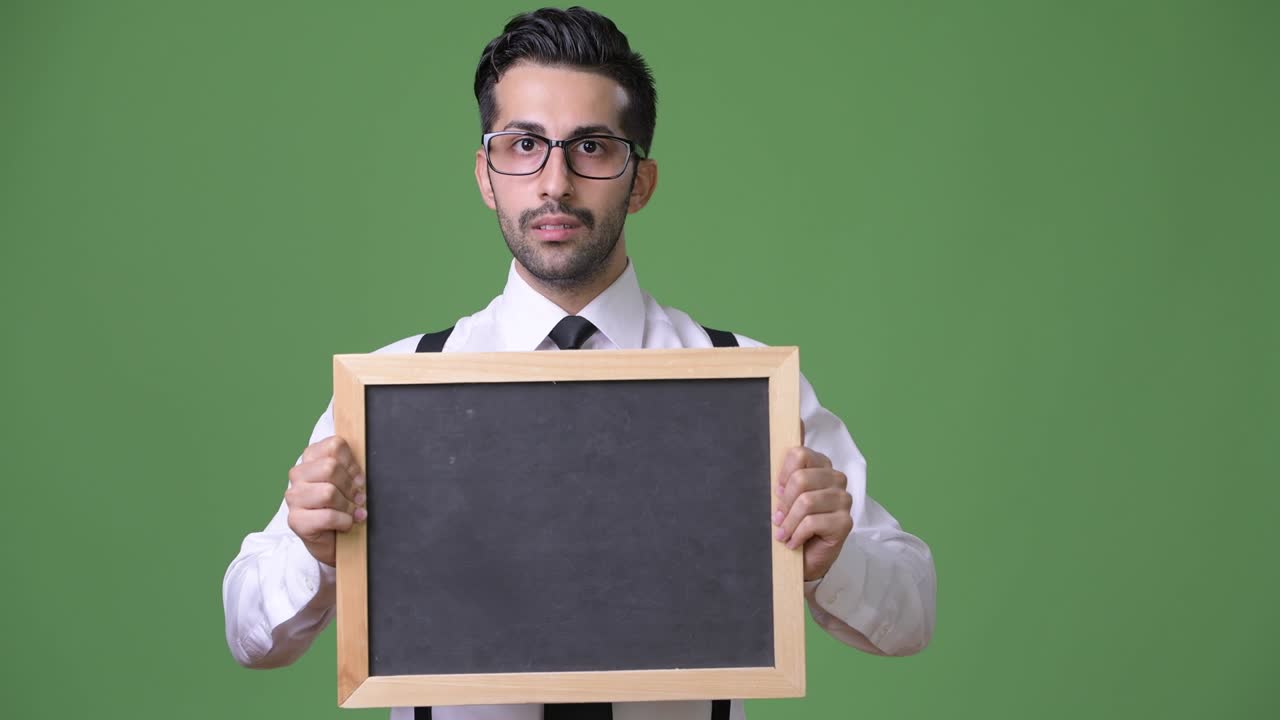 초록색 배경에 젊은 잘생긴 수염을 가진 페르시아 사업가