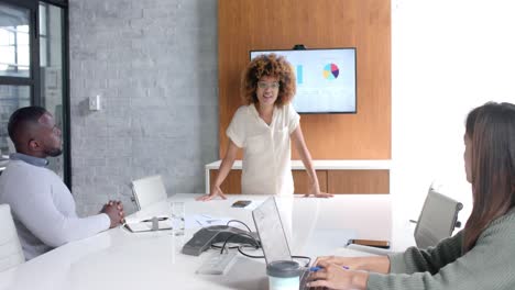 diversos colegas masculinos y femeninos en una reunión de oficina, usando computadora portátil y monitor, cámara lenta
