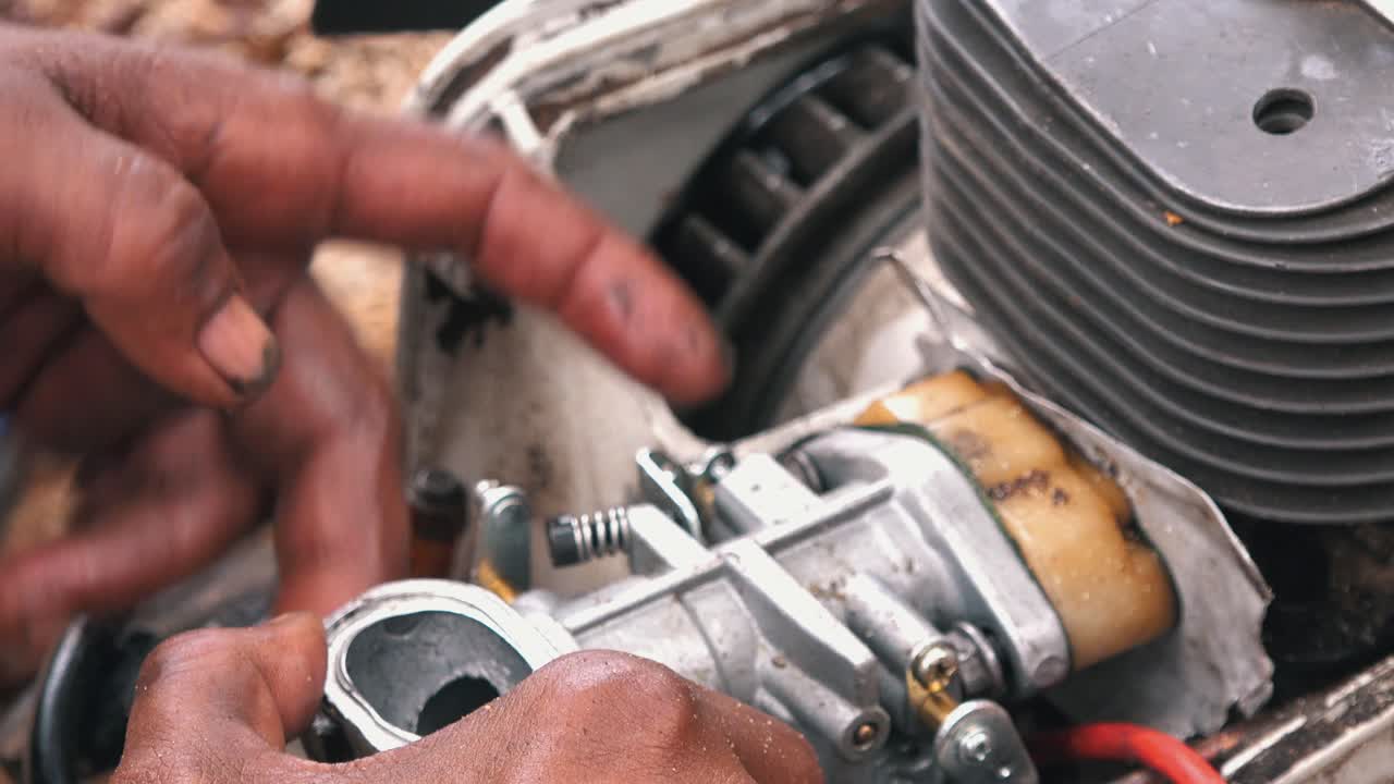 Close Shot of Hands Working on a Chainsaw Engine