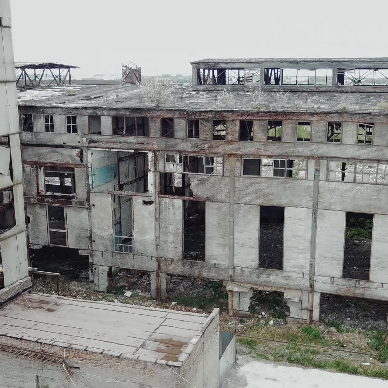 Aerial view of an old factory ruin and broken windows. Old industrial building for demolition.