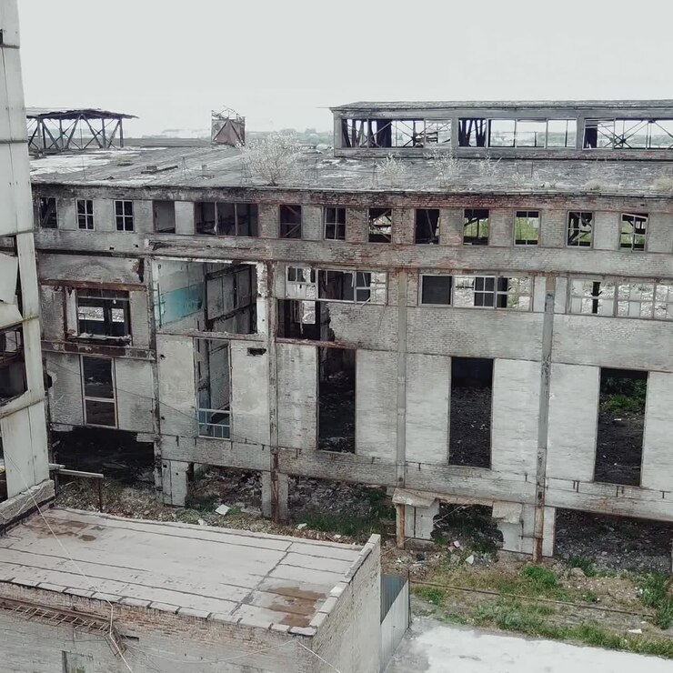 Aerial view of an old factory ruin and broken windows. Old industrial building for demolition.